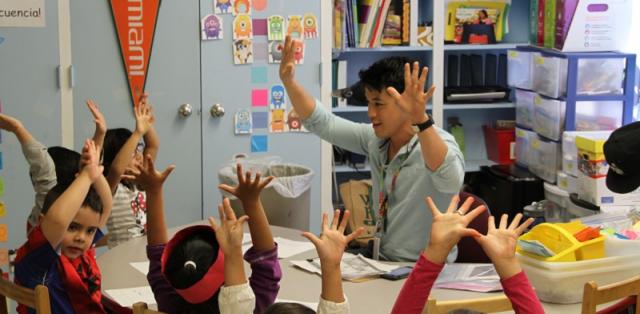 First graders with hands raised