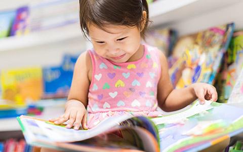 PreK student with book